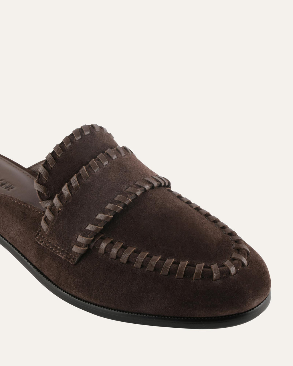 Brown suede loafer with braided detail on a white background
