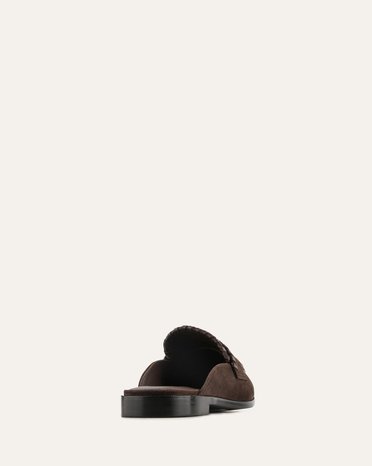Brown suede loafers with a pom-pom on a white background